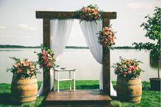 an outdoor ceremony setup with flowers and curtains