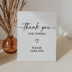 a thank you for coming sign next to a vase with dried grass in it on a table