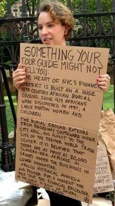 a girl holding up a sign that says something your tour guide might not tell you