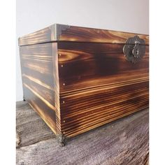 a large wooden box sitting on top of a piece of wood with an iron handle