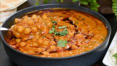 a black bowl filled with food and garnished with cilantro on top