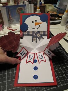 someone is making a snowman card out of paper