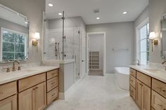 a large bathroom with two sinks, tub and walk - in shower next to each other