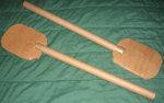 two wooden paddles laying on top of a green sheet