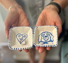 two people holding small dishes with designs on them, one is blue and the other is white