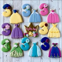 decorated cookies are arranged in the shape of princesses and prince's crowns on a white wooden surface