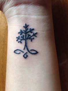 a wrist tattoo with a tree on it