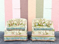 two chairs sitting next to each other in front of a wall