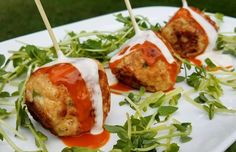 three appetizers with toothpicks are sitting on a plate covered in greens