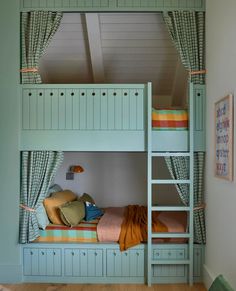 a bunk bed with two sets of drawers underneath it and curtains hanging from the ceiling