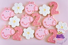 pink and white decorated cookies in the shape of numbers with pigs, flowers and butterflies