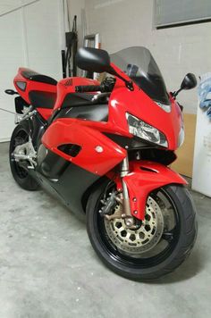 a red and black motorcycle parked in a garage