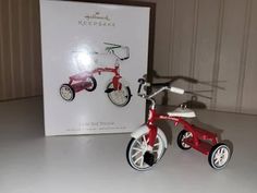 a red and white tricycle next to a box