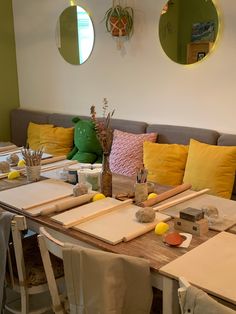 the table is set up with place mats and yellow pillows on it, along with other items