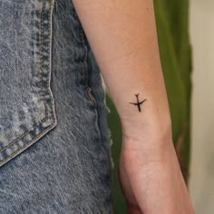 a small cross tattoo on the wrist