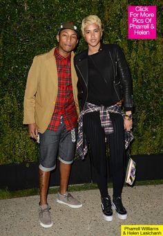 a man and woman standing next to each other in front of a wall with plants