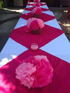 pink and white table cloths with flowers on them are set up for a party