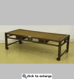 a wooden coffee table with wheels on the bottom and one drawer open to reveal an empty shelf