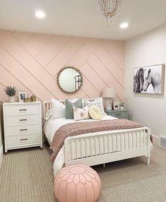 a bedroom with pink walls and white furniture