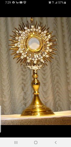 a golden clock is sitting on top of a table