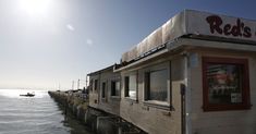 a restaurant sitting on the side of a body of water