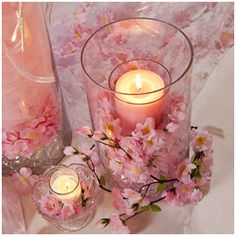 some pink flowers and candles on a table