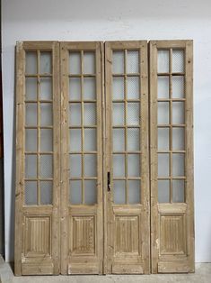 three wooden doors sitting next to each other in a room with white walls and flooring