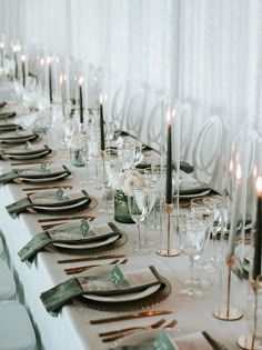 a long table is set with place settings and candles