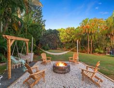 a fire pit surrounded by lawn chairs and hammocks