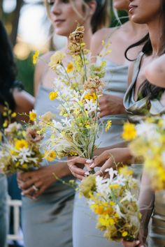 the bridesmaids are holding their bouquets with yellow and white flowers on them