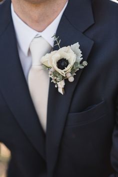 a man in a suit and tie wearing a boutonniere