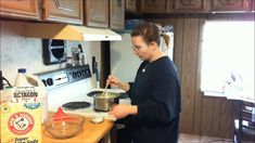 a woman standing in front of a stove preparing food on top of a wooden counter