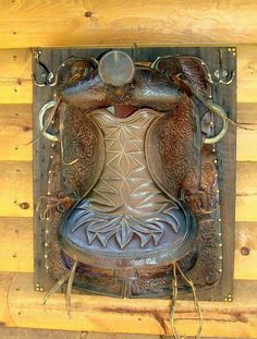 an intricately designed metal object on the side of a wooden wall