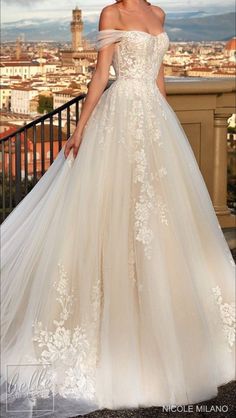 a woman in a wedding dress standing on top of a balcony looking at the camera