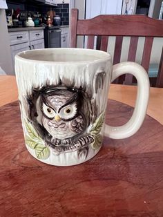 an owl mug sitting on top of a wooden table