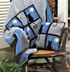 a blue and white afghan sitting on top of a wooden chair next to a potted plant