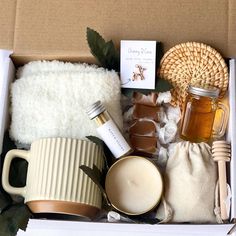 an open box containing honey, candles and other items