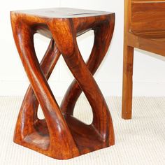 a wooden table with an unusual design on it's top and bottom, next to a chair