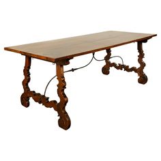 an old wooden table with wheels on the legs and a long wood table top that is turned upside down