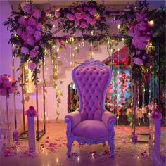 a purple chair sitting in the middle of a room with pink flowers on it's walls