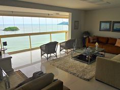 a living room filled with furniture next to a large window covered in glass and wood