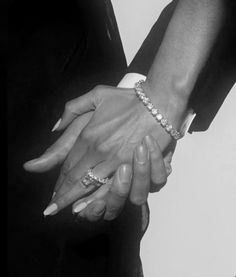 two people are holding hands and wearing bracelets