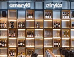 an empty bar with lots of bottles on the wall and shelves full of wine glasses