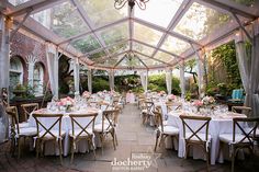 the inside of a tent with tables and chairs set up for an outdoor wedding reception