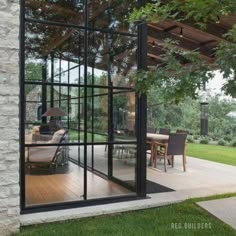 an open patio with glass walls and sliding doors leading to the outside dining room area