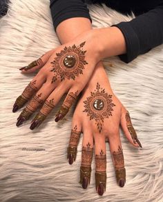 two hands with henna tattoos on them, one is brown and the other is white