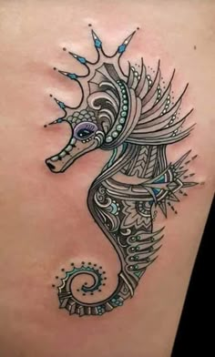 a sea horse tattoo on the back of a woman's stomach, with intricate designs