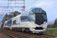 a blue and white train traveling down tracks