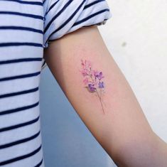 a woman's arm with purple flowers on it