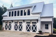 a large white house with two garages and three windows